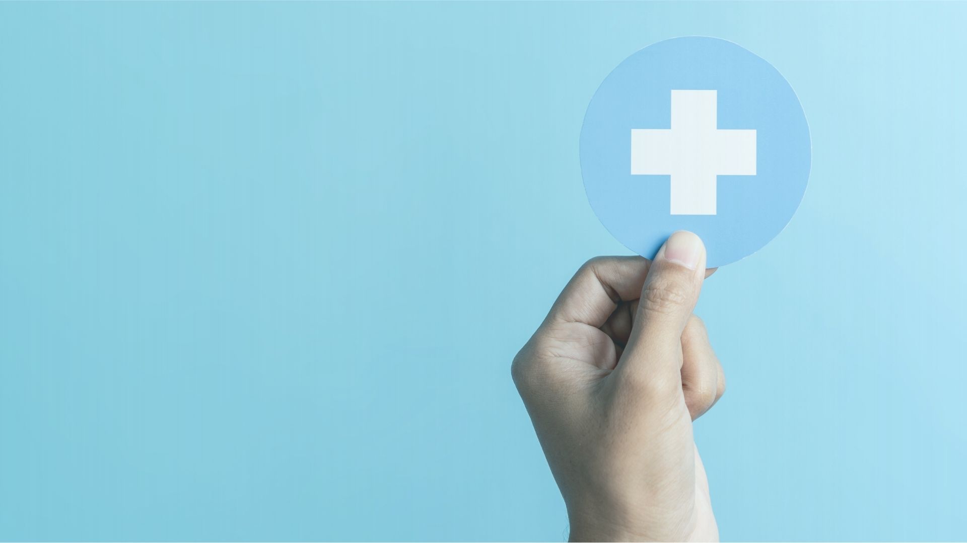 Hand holding a medical cross